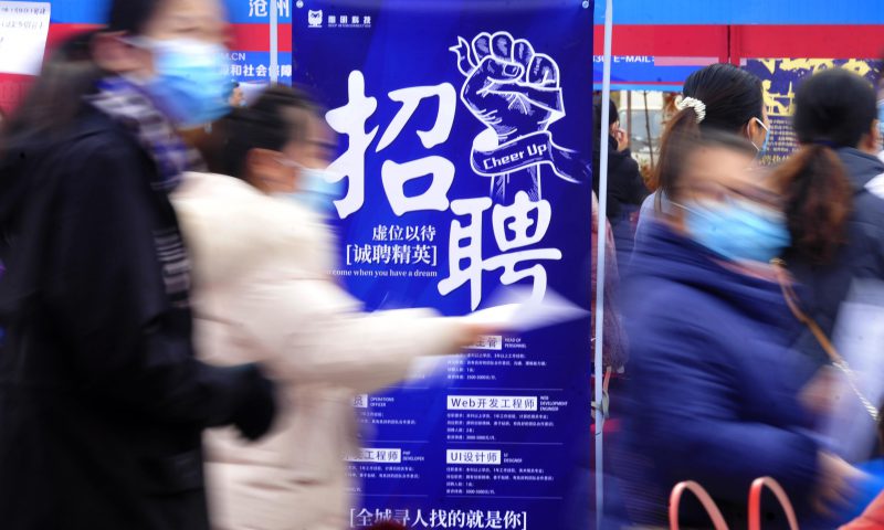 求職者從一家招聘企業的廣告牌前走過。新華社發（苑立偉 攝）